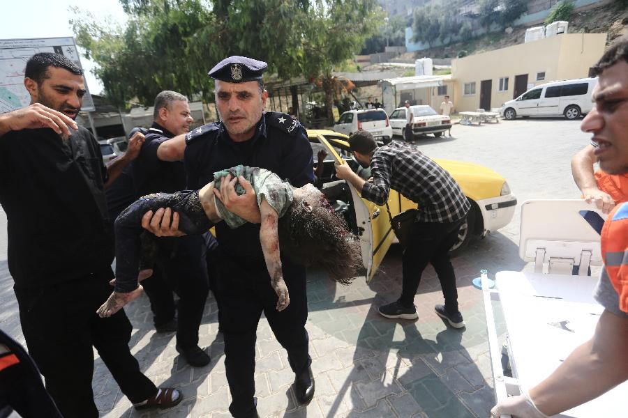 Policajac Hamasa nosi ranjenu djevojčicu nakon izraelskog raketiranja Pojasa Gaze